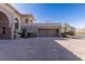 Large brick driveway leading to a luxurious home with stone detailing and meticulously maintained landscaping at 9631 Orient Express Ct, Las Vegas, NV 89145