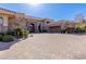 Wide brick driveway leads to a beautiful home with stone accents and manicured landscaping for added curb appeal at 9631 Orient Express Ct, Las Vegas, NV 89145