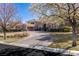 Elegant home showcasing a brick driveway, manicured lawn, and mature trees providing a welcoming entrance at 9631 Orient Express Ct, Las Vegas, NV 89145