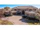 Stately home featuring a stone facade, multiple garages, arched windows, and manicured landscaping at 9631 Orient Express Ct, Las Vegas, NV 89145