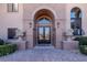 Close-up showcasing the elegant front entrance with decorative doors, stonework, and manicured greenery at 9631 Orient Express Ct, Las Vegas, NV 89145