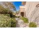 Inviting front entrance with lush landscaping, stone pathway, and covered doorway providing shade and curb appeal at 9631 Orient Express Ct, Las Vegas, NV 89145