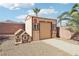 Features a storage shed, small dog house, rock landscaping, block wall and green trees at 1011 Amber Gate St, Henderson, NV 89002