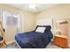 Bedroom featuring a comfortable bed, ceiling fan, wood floors, and a bright window at 1011 Amber Gate St, Henderson, NV 89002