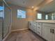 Modern bathroom featuring double vanity, tile floors, and glass shower with window at 10246 Bloom Quick Ct, Las Vegas, NV 89141