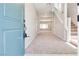 Inviting entryway featuring a carpeted floor, stairs to the upper level, and a view of the open-concept living area at 10246 Bloom Quick Ct, Las Vegas, NV 89141
