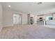 Open-concept living room and kitchen featuring carpeted floors, stainless steel appliances, and light gray walls at 10246 Bloom Quick Ct, Las Vegas, NV 89141