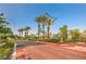 Community entrance featuring palm trees, lush greenery, and well-maintained roads for a welcoming arrival at 10321 Birch Bluff Ln, Las Vegas, NV 89145