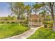 Community gazebo surrounded by lush green landscaping and mature trees at 10321 Birch Bluff Ln, Las Vegas, NV 89145