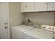 Convenient laundry room with white cabinets and modern washer and dryer at 10321 Birch Bluff Ln, Las Vegas, NV 89145