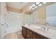 Well-lit bathroom with double sink vanity, tile floors, and shower-tub combination at 10332 Sweet Laurel St, Las Vegas, NV 89178