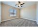 Neutral bedroom with a ceiling fan, large window, and carpet flooring at 10332 Sweet Laurel St, Las Vegas, NV 89178
