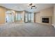 Open-concept living room with a fireplace, curved wall with ample windows and natural light at 10332 Sweet Laurel St, Las Vegas, NV 89178