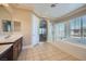 Bright main bathroom featuring a luxurious tub, shower, and neutral tile floors at 10332 Sweet Laurel St, Las Vegas, NV 89178