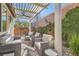 Outdoor patio area featuring stylish wicker furniture, overhead pergola, and lush landscaping at 1045 Chestnut Chase St, Las Vegas, NV 89138
