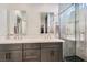 Elegant bathroom featuring a double sink vanity, a glass-enclosed shower, and stylish mirrors at 1045 Chestnut Chase St, Las Vegas, NV 89138