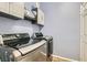 Laundry room with side-by-side stainless steel washer and dryer and white wall-mounted storage cabinets at 1045 Chestnut Chase St, Las Vegas, NV 89138