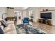 Open-concept living room featuring a large window, stylish furniture, and hardwood floors at 1045 Chestnut Chase St, Las Vegas, NV 89138