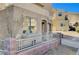 Beige stucco home with covered parking, arched entry, and iron-gated and brick-lined front yard at 10505 Cold Mountain Ave, Las Vegas, NV 89129