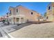 Two-story home features beige stucco, arched entry, fenced yard, and two-car covered parking at 10505 Cold Mountain Ave, Las Vegas, NV 89129