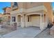 Beige stucco home with covered parking, arched entry, and iron-gated and brick-lined front yard at 10505 Cold Mountain Ave, Las Vegas, NV 89129