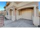 Beige stucco home with covered parking, arched entry, and iron-gated and brick-lined front yard at 10505 Cold Mountain Ave, Las Vegas, NV 89129