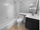 Clean bathroom with a shower-tub combo, white tiles, and dark vanity at 10524 India Hawthorn Ave, Las Vegas, NV 89144