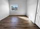 Bright bedroom with a neutral palette, wood floors and large sunny window at 10524 India Hawthorn Ave, Las Vegas, NV 89144