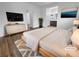 Staged main bedroom with wood-look floors, neutral walls, and ensuite bathroom at 10524 India Hawthorn Ave, Las Vegas, NV 89144