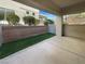 Private covered patio area with concrete flooring and artificial turf at 10524 India Hawthorn Ave, Las Vegas, NV 89144