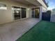 Private outdoor patio with artificial turf and two sliding glass door entrances at 10524 India Hawthorn Ave, Las Vegas, NV 89144