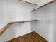 Well organized walk-in closet with built-in shelving and wood-look floor at 10524 India Hawthorn Ave, Las Vegas, NV 89144