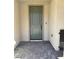Welcoming front entrance with a modern gray-green door, brick flooring, and smooth stucco walls at 11443 Ethereal Landing Ave, Las Vegas, NV 89138