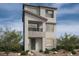 Modern three-story home with gray stucco exterior, small balcony, and minimalist landscaping at 1513 Bat Hawk St, Las Vegas, NV 89144