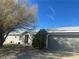 Single-story home with light grey exterior, attached garage, and mature tree at 1640 E Kearney St, Pahrump, NV 89048