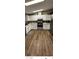 Bright kitchen featuring white cabinets, stainless steel appliances, and stylish wood-look flooring at 1640 E Kearney St, Pahrump, NV 89048