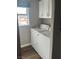 Bright laundry room with white washer and dryer, upper cabinets and window at 1640 E Kearney St, Pahrump, NV 89048