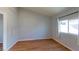 Bright bedroom with a large window, wood-look flooring, and light gray walls at 173 Betty Ln, Las Vegas, NV 89110