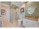 Stylish bathroom with a glass-enclosed shower, decorative mirror, and marble countertops at 2 Camino Barcelona Pl, Henderson, NV 89011