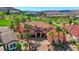 Stunning Mediterranean-style home featuring a red tile roof, lush palm trees, and a circular driveway in a golf course community at 2 Camino Barcelona Pl, Henderson, NV 89011