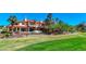 Expansive estate home featuring a terracotta roof, balcony, and large windows, set against a lush green lawn at 2 Camino Barcelona Pl, Henderson, NV 89011