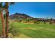 View of a lush green golf course with mature trees and elegant homes in the distance at 2 Camino Barcelona Pl, Henderson, NV 89011