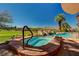 Inviting hot tub with stone surround, complemented by a pool and scenic views of the surrounding landscape at 2 Camino Barcelona Pl, Henderson, NV 89011