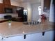 Well-lit kitchen with granite countertops, stainless sink, and wooden cabinetry at 2351 Thornwood Castle Dr, Laughlin, NV 89029