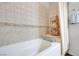 Clean bathroom showcasing a tub with decorative tile and storage shelves at 2455 W Serene Ave # 603, Las Vegas, NV 89123