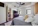 Bright bedroom with a modern ceiling fan, two windows, and view to the living room at 2455 W Serene Ave # 603, Las Vegas, NV 89123