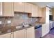 Kitchen features stainless dishwasher, granite countertops, and light wood cabinets with backsplash at 2455 W Serene Ave # 603, Las Vegas, NV 89123