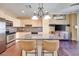 Open-concept kitchen with island, granite counters, stainless steel appliances, and wood-look flooring at 2455 W Serene Ave # 603, Las Vegas, NV 89123