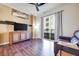 A cozy living room features hardwood floors, TV, and a sliding glass door to a balcony at 2455 W Serene Ave # 603, Las Vegas, NV 89123