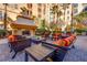 Close up of outdoor fireplace and seating area with multiple chairs and tables for relaxing at 2455 W Serene Ave # 603, Las Vegas, NV 89123